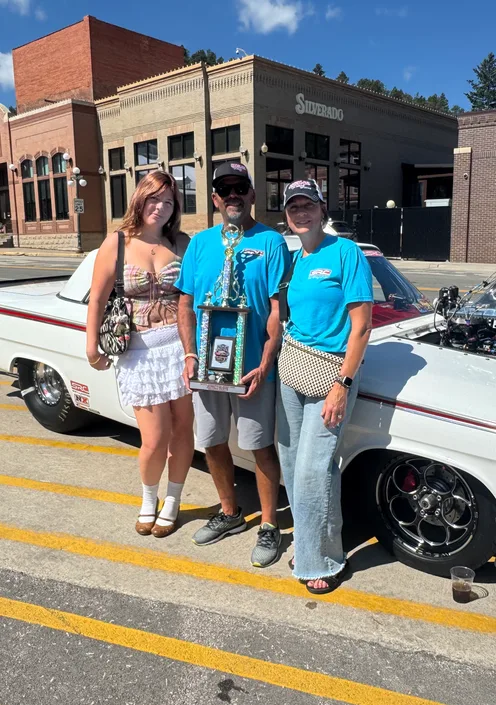 Event hosts with a car show trophy